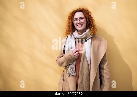 Portrait naturel d'une femme au gingembre caucasien souriant avec des taches de rousseur et des cheveux bouclés. Banque D'Images