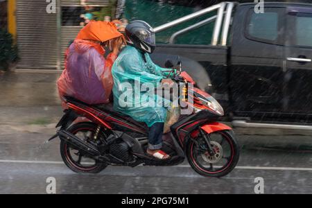 Couple en imperméable conduire sous la pluie Banque D'Images