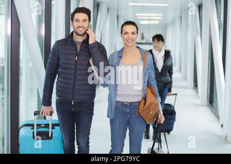 couple heureux marchant dans le couloir de l'aéroport Banque D'Images