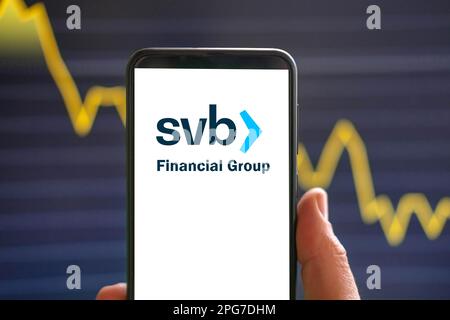 Kostanay, Kazakhstan - 21 mars 2023 : main tenant un téléphone avec le logo de la banque de la vallée de la silicone sur un écran blanc vierge. Symbole de banque SVB. Effondrement bancaire 2023. Banque D'Images