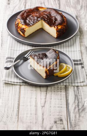 Cheesecake basque fraîchement cuit au four espagnol brûlé sur l'assiette de la table. Verticale Banque D'Images