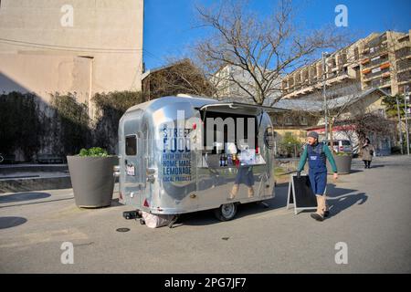 Caravane métallique transformée en camion alimentaire sous le soleil d'hiver dans un petit parc à Genève, Suisse Banque D'Images