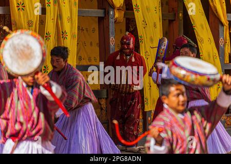 TRONGSA, BHOUTAN - 6 JANVIER 2017 : Jokster regardant des moines répéter la danse des démons dans le Seigneur de la mort au festival Tsechu dans le Trondsa Dzong Banque D'Images