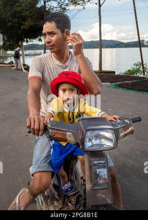 Un jeune père de minorité ethnique m'nong et son fils sur un trottinette Honda à Jun Village, lien son, Vietnam. Banque D'Images