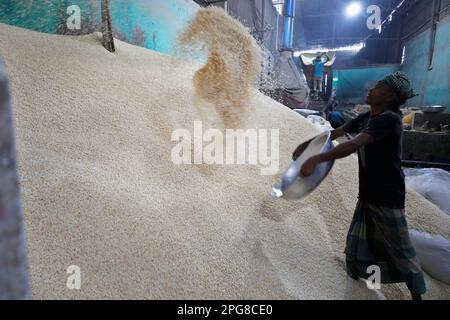 Narayanganj, Bangladesh - 21 mars 2023: Les travailleurs travaillent jour et nuit dans l'usine pour répondre à la demande de riz soufflé (Muri) pendant le mois Saint Banque D'Images