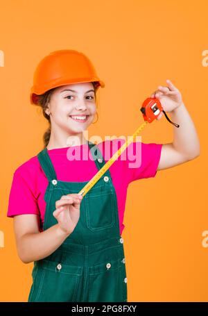 longueur. ouvrier de construction avec mètre ruban. Mignon enfant comme ouvrier de construction. Enfant répare la maison. Enfance heureuse. Auto-rétractable ruban métal meas Banque D'Images