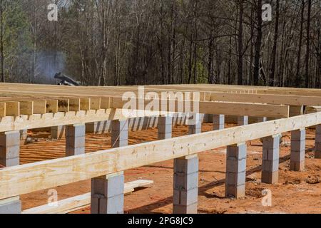 Travaux sur de nouvelles maisons personnalisées fondations en blocs de béton installation de poutrelles de poutrelles de bois Banque D'Images