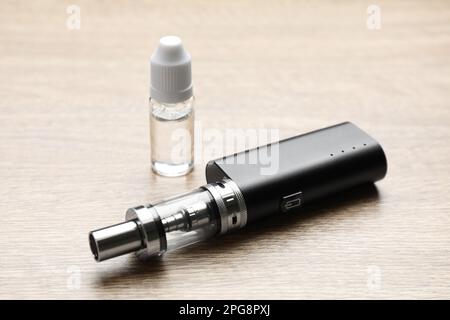 Cigarette électronique et liquide de vapotage sur table en bois. Alternative fumeurs Banque D'Images