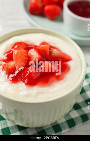 Délicieux pudding à la semoule avec des fraises et de la confiture sur une table blanche Banque D'Images