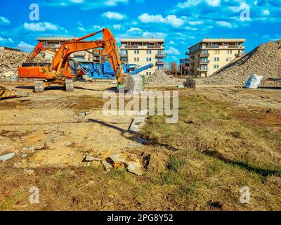 Excavatrice Orange sur le site de la cale, démontage du bâtiment Banque D'Images