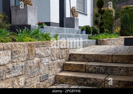 Jardin avant bien entretenu avec des marches en pierre naturelle et en granit Banque D'Images