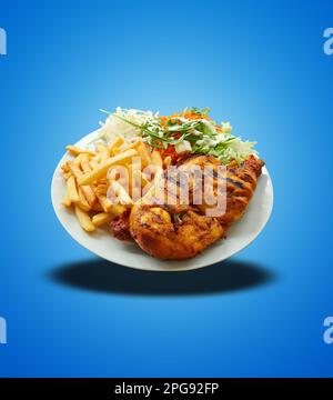 Flottant de Piri Piri Chicken sur une plaque blanche sur fond bleu dégradé Banque D'Images