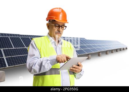 Ingénieur homme mature utilisant une tablette numérique dans une ferme solaire isolée sur fond blanc Banque D'Images