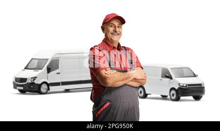 Conducteur de fourgonnette en uniforme souriant à la caméra et posant devant deux fourgonnettes blanches isolées sur fond blanc Banque D'Images