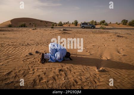 Brahim Ramdhane, ancien esclave et fondateur de son ONG Fondation Sahel, ici à la prière de Sunite dans le désert entre Nouakshott et sa ville natale de Boutilimit en Mauritanie, où il a grandi en tant qu'esclave. Il lutte contre l'esclavage, contre l'oppression de sa tribu Haratin et pour des opportunités éducatives équitables depuis qu'il s'est libéré comme adolescent. Banque D'Images