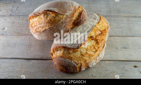 Pain croustillant fait maison sur un panneau de bois fait à partir de levure et de farine blanche bio forte, yaourt, miel et eau. Banque D'Images