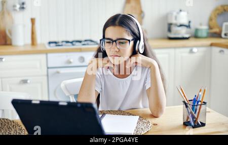 Jolie fille 12s porter des écouteurs et des lunettes faire la tâche, étudier en ligne, éprouve des problèmes de vision, des calmars, avoir la vue tombe, problèmes de santé Banque D'Images