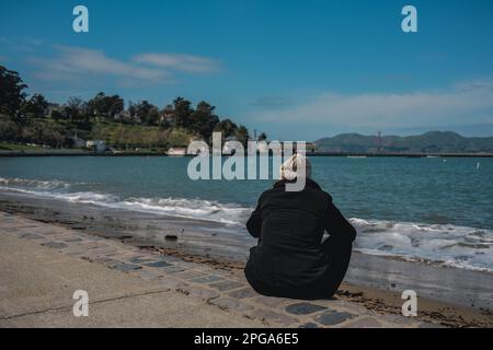 Les gens s'assoient sur la plage de Ghirardelli Square, bénéficiant d'une vue magnifique sur la baie de San Francisco et l'océan au-delà. Ghirardelli Square, situé dans le quartier emblématique de Fisherman's Wharf à San Francisco, est un monument historique qui délimite les habitants et les touristes depuis plus de 50 ans. Construite en 1893 comme siège social de la Ghirardelli Chocolate Company, la place a subi de nombreuses rénovations et modifications au fil des ans, mais est restée une destination appréciée pour les magasins, les restaurants et les divertissements. (Photo de Chin Hei Leung/SOPA Images/Sipa USA) Banque D'Images