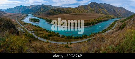 Panorama depuis la falaise au-dessus de la rivière Katun rapide sous la montagne et la route près des chalets de vacances à Altai en Russie en automne. Banque D'Images