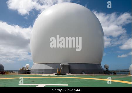 L'Agence de défense antimissile (MDA) a organisé une visite du radar en bande X (SBX) basé sur la mer sur l'île Ford à la base conjointe Pearl Harbor-Hickam, Hawaï, 2 mars 2023. Des membres des médias locaux ont eu l’occasion de visiter le SBX-1, connu des locaux comme la « balle de golf » géante. Après un record de 662 jours en mer, le SBX-1 subit régulièrement des opérations de maintenance et de mise à niveau du système. Le MDA affirme qu’il s’agit du radar mobile le plus grand et le plus puissant du genre au monde. (É.-U. Photo de la marine par Joanne Tumacder) Banque D'Images