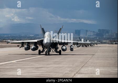 Trois États-Unis Des growlers EA-18G de la Marine affectés à l'escadron d'attaque électronique (VAQ) 132, à la base aérienne de la Marine de l'île Whidbey (Washington), taxi sur la piste avant de décoller pour une mission Red Flag-Nellis 23-2 à la base aérienne de Nellis, Nevada (15 mars 2023). Le Growler est un dérivé du F/A-18 Hornet, l’avion de frappe maritime de la marine américaine. Sa mission est principalement l'attaque électronique et la suppression des défenses aériennes ennemies, en particulier au début et en cours des premières phases des hostilités. (É.-U. Photo de la Force aérienne par le premier Airman Zachary Rufus) Banque D'Images