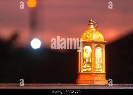 Lanternes décoratives en arabe avec bougies allumées la nuit. Lumières en bokeh dorées étincelantes. Carte de vœux de fête, invitation. Ramadan, le mois Saint des musulmans Banque D'Images