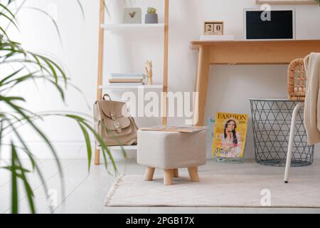 Pouf élégant avec magazine au sol dans un bureau moderne. Design intérieur Banque D'Images