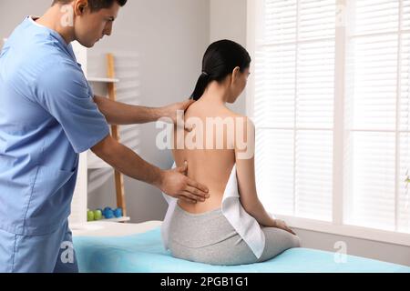 Orthopédiste examinant le retour de la femme en clinique. Traitement par scoliose Banque D'Images