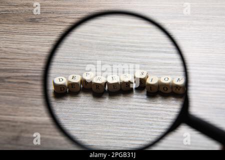 Mot Dépression fait de cubes en bois sur la table, vue à travers la loupe Banque D'Images