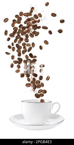 Grains de café torréfiés aromatiques tombant dans une tasse sur fond blanc Banque D'Images