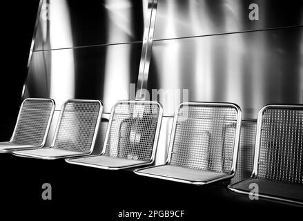 Photographie en noir et blanc, sièges chromés sur une plate-forme, Berlin, Allemagne Banque D'Images