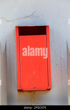 Boîte aux lettres REM montée sur un mur gris fissuré Banque D'Images