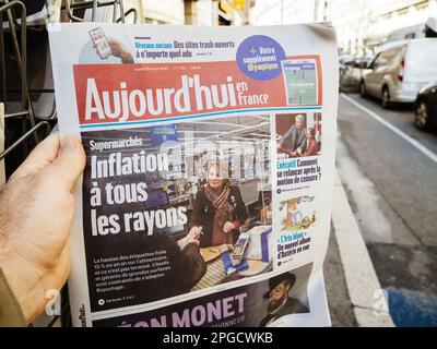 Paris, France - 20 mars 2023 : le journal Aujordd'hui en France lu dans la main masculine avec le titre de titre Supermarches inflation a tous les rayons - supermarché, inflations à tous les niveaux Banque D'Images