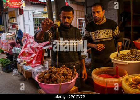 Gaza, bande de Gaza, Palestine. 21st mars 2023. Gaza, Palestine. 21 mars 2023. Les Palestiniens préparent leurs stalles pour le Ramadan dans le traditionnel marché Al-Zawiya de la ville de Gaza. Un large choix de bonbons, de dattes, d'olives, et le plat d'aubergine de Makdous, ont été parmi les nombreux produits alimentaires exposés sur le marché. D'autres stands étaient remplis de lanternes colorées ainsi que de vêtements et d'autres ornements pour la célébration du mois musulman sacré du Ramadan (Credit image: © Ahmad Haaballah/IMAGESLIVE via ZUMA Press Wire) USAGE ÉDITORIAL SEULEMENT! Non destiné À un usage commercial ! Banque D'Images