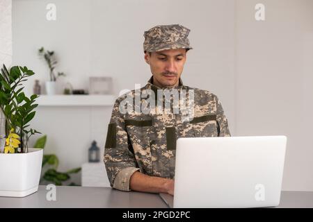 Surveillance et contrôle du concept d'information opposé, Soldier en uniforme de camouflage travaillant sur ordinateur portable pour opération d'information Banque D'Images