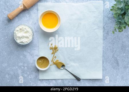 Faites tourner le pain avec de la crème pistache. Pâte crue avec ingrédients sur la table. Pâtisserie festive Banque D'Images