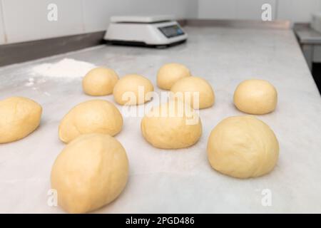 Pâte à pain pour hamburgers formée en boules de pâte sur un comptoir en marbre Banque D'Images