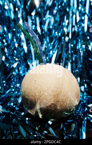 Boisson à l'eau de coco avec 2 pailles en verre lors d'une fête. Jus de noix de coco frais sur fond étincelant Banque D'Images