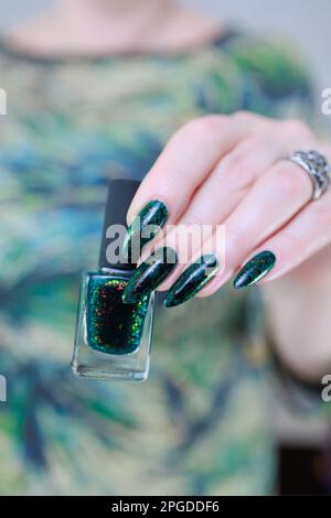 Main de femme avec de longs ongles et vernis à ongles vert foncé Banque D'Images