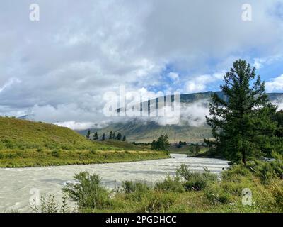 Le village du village est en couture sur la rive opposée de la rivière Chui avec brouillard sur la montagne le matin. Banque D'Images