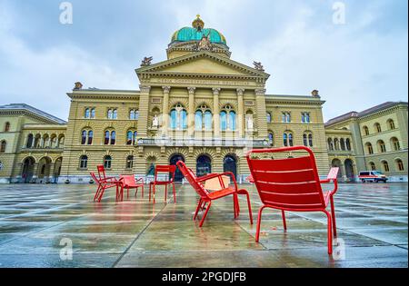 Les chaises rouges sur la place du Bundeshaus dans le bâtiment du Bundeshaus (Palais fédéral) à Berne, Suisse Banque D'Images