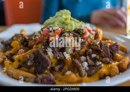 Gros plan d'une assiette de frites au carne asada avec guacamole sur le dessus. Il s'agit d'une spécialité locale de certaines parties de l'Arizona et de la région de San Diego en Californie. Banque D'Images