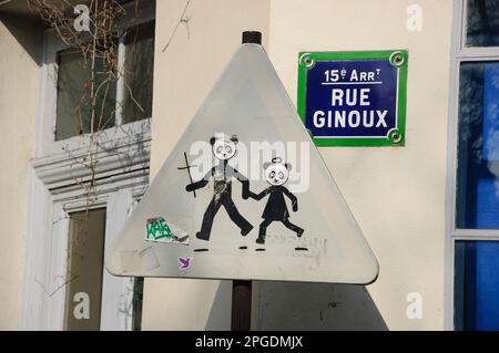 La vie urbaine. Saint Panda Bears traverse la route. Panneau de signalisation routière Avertissement enfants Crossing drôle «corrigé». Paris, France. Banque D'Images