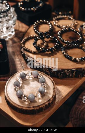 Bracelets de perles de pierre sur un support en bois naturel Banque D'Images