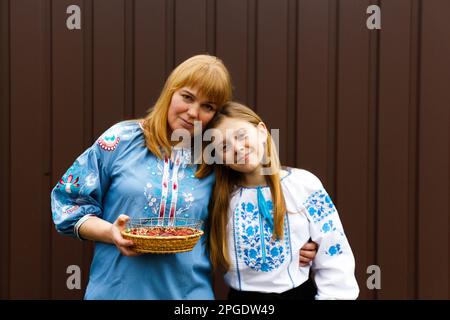 La famille de Pâques. Mère et fille tenant des oeufs de Pâques et embrassant. Regarder l'appareil photo. Peuple ukrainien. Hors foyer. Banque D'Images