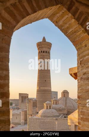 Boukhara, Ouzbékistan. Vue sur Kalon Minaret par la fenêtre au coucher du soleil Banque D'Images