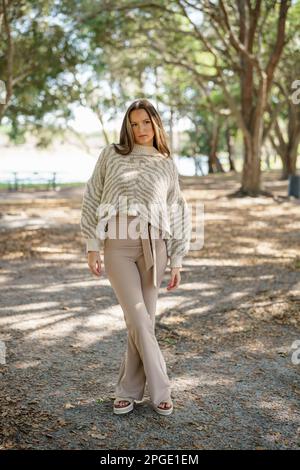 Belle jeune femme posant dans la nature avec des tons beige Banque D'Images