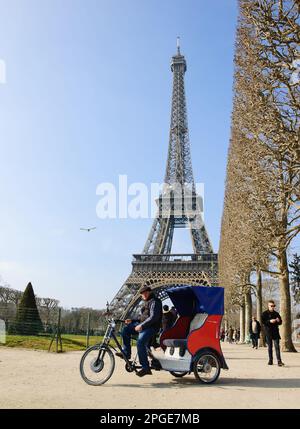 PARIS, FRANCE - 26 MARS 2016: Trishaw en pédicab aux couleurs du drapeau français offre ses services au champ de Mars. La Tour Eiffel en arrière-plan. Banque D'Images