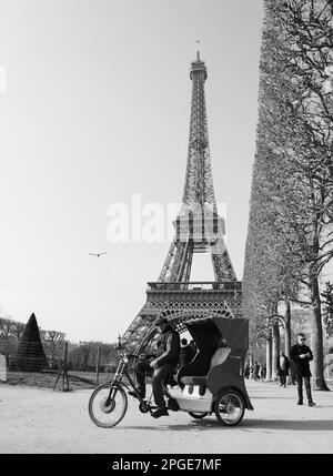 PARIS, FRANCE - 26 MARS 2016: Trishaw en pédicab offre ses services au champ de Mars. La Tour Eiffel en arrière-plan. Photo historique noir blanc Banque D'Images