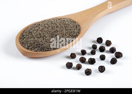 Poivre noir moulu avec grains de poivre noir sur fond blanc Banque D'Images
